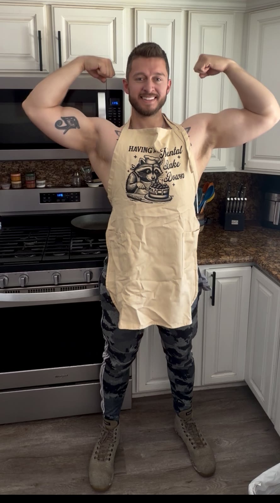 Coach Dylan flexing in a kitchen apron