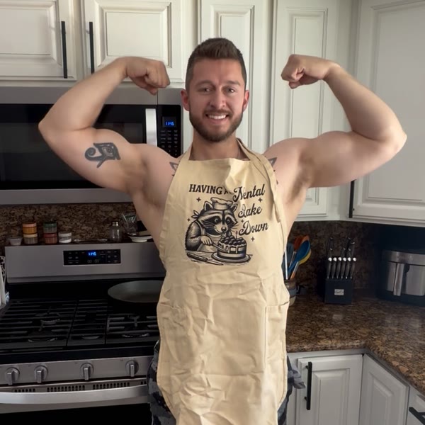 Coach Dylan flexing in a kitchen apron